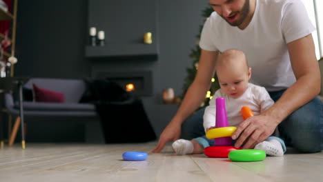 concepto de familia, paternidad y personas - padre feliz con un hijo pequeño jugando con juguetes en casa
