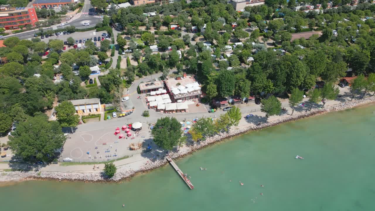 vista aérea de las aguas de la orilla del lago garda en italia con árboles y la ciudad