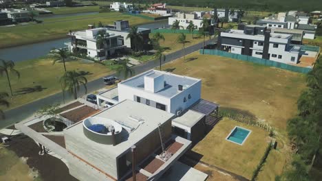 contemporary designed houses built on the lush village in ponta da figueira in brazil surrounded with tall palm trees - aerial shot