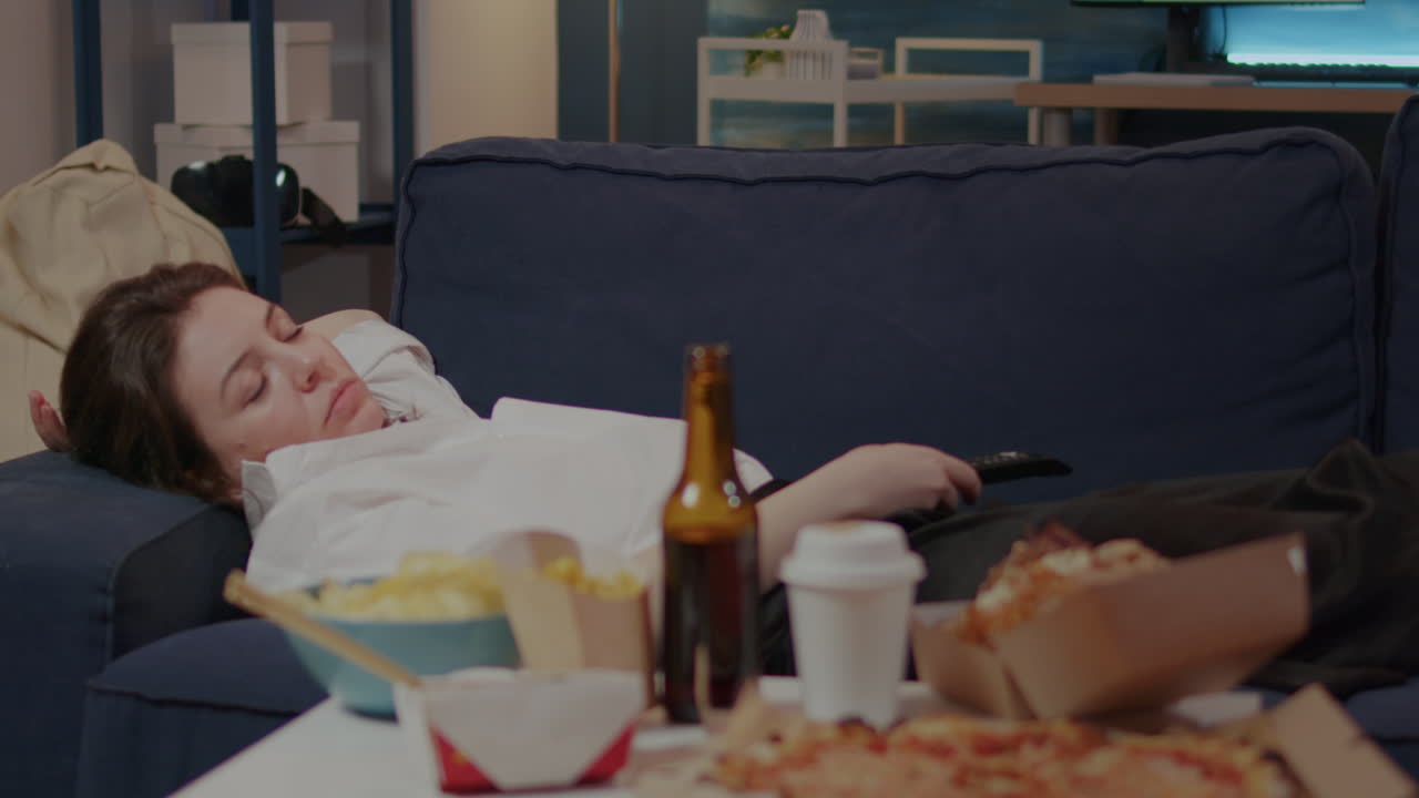 Businesswoman falling asleep on couch after eating meal