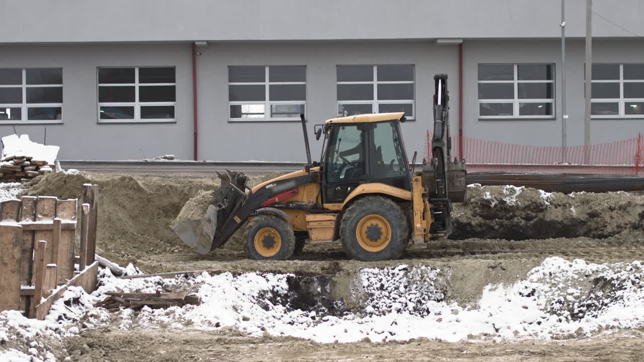 Excavator working on a construction site in winter