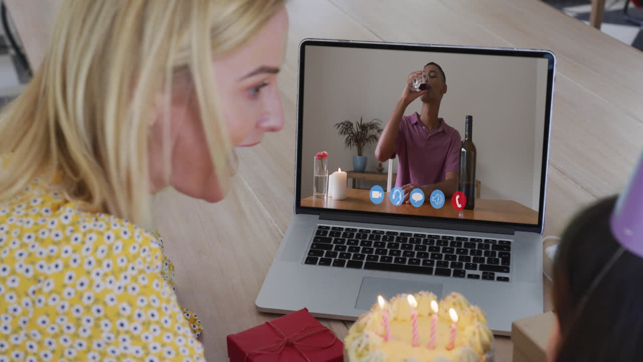 madre y hija caucásicas celebrando su cumpleaños haciendo una videollamada en una computadora portátil en casa