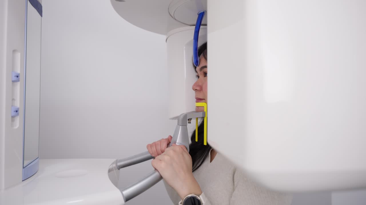 Ung kvinne gjennomgår panoramisk tannrøntgen på klinikk