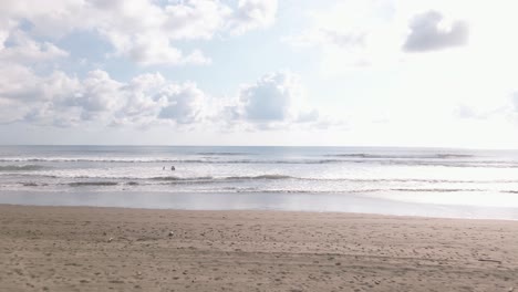 aerial view of three people in the dominical beach in costa rica, tracking shot wide