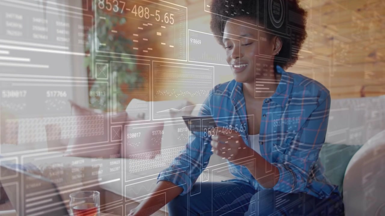Woman holding payment card and tapping laptop pad in home, holo UI expanding confirming purchase