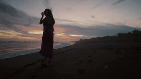 traveler woman wearing dress on the beach during sunset