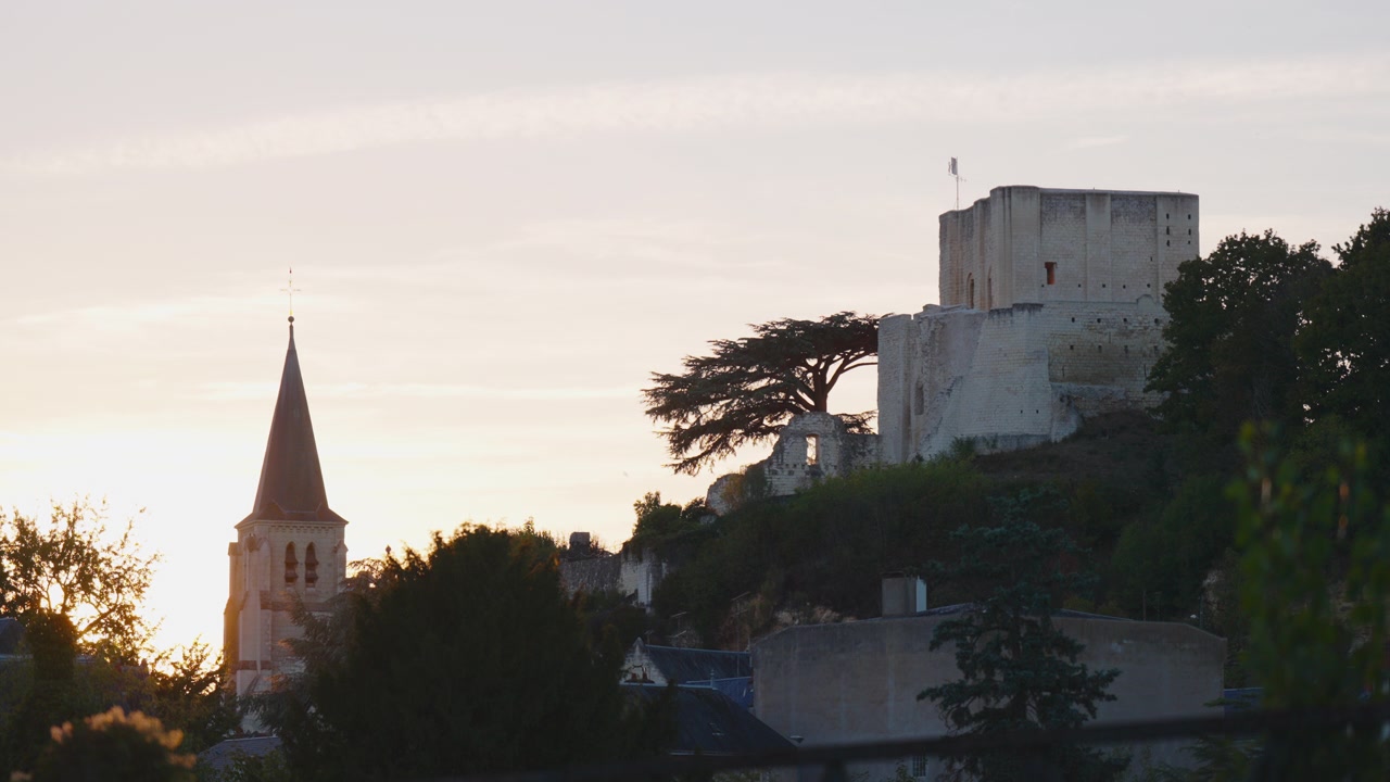 Castello storico in pietra e guglia della chiesa all'alba a Montrichard, ambientazione di villaggio.