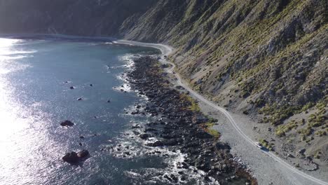 Descending-towards-a-gravel-coastal-road-with-off-road-vehicles-driving