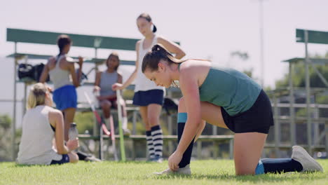 a young female sports person kneeling tying