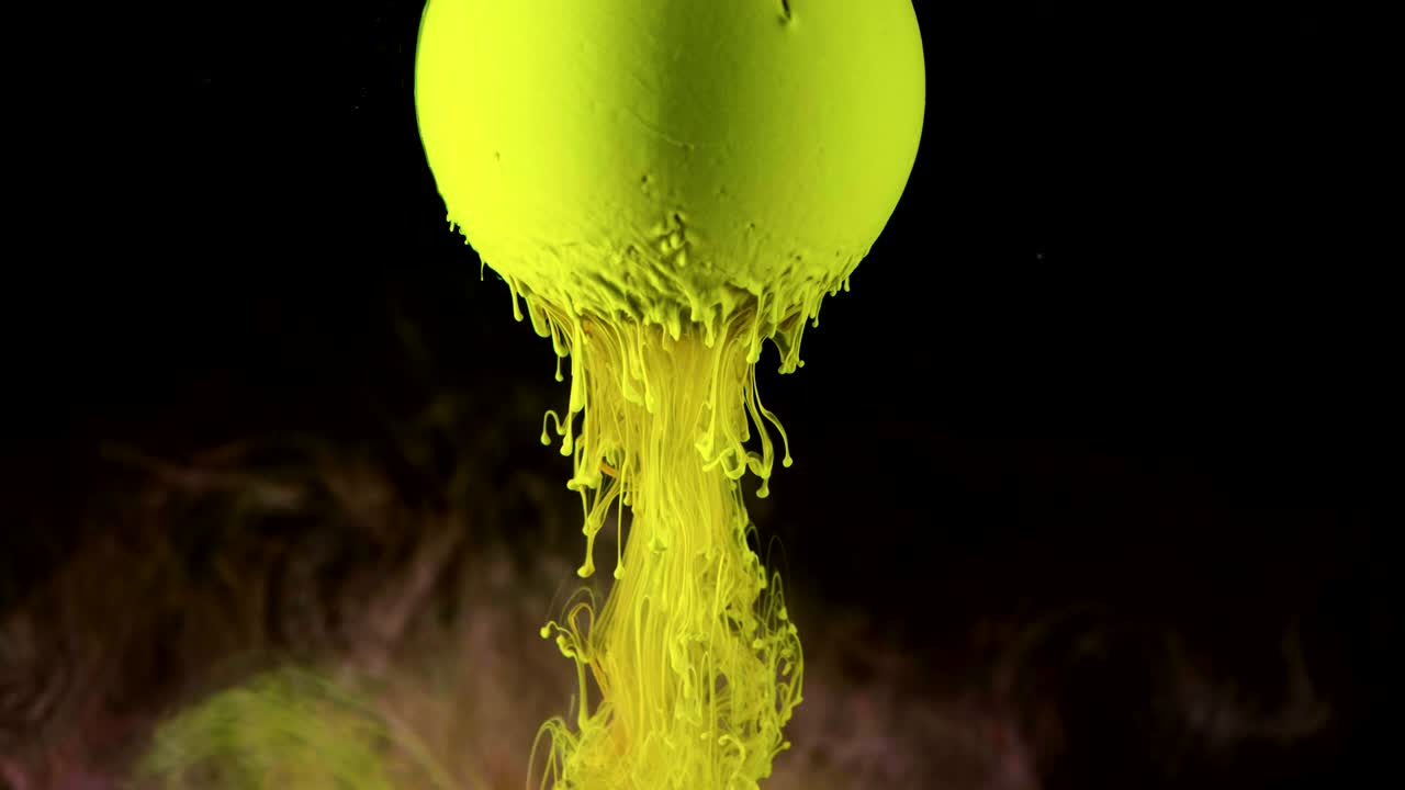la pintura de tinta verde fluye lentamente desde la pelota.