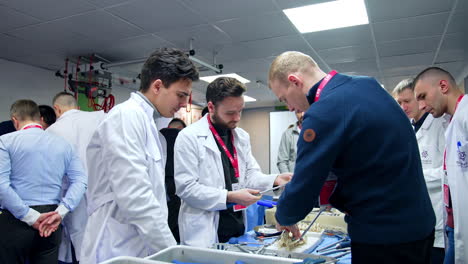 future neurosurgeons apply modern medical tools and devices at the dummy of a spine. neurosurgery practice in progress.