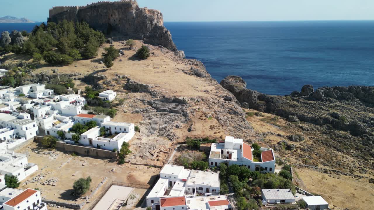 Mythical Lindos ancient amphitheatre aerial drone approach and fly up, Rhodes, Greece