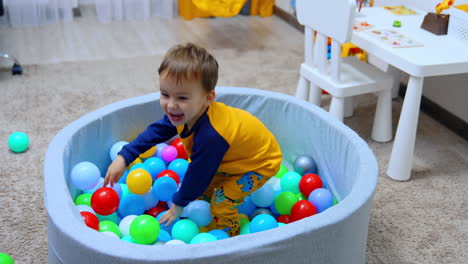 happy smiling caucasian baby jumping in the dry pool. little kid having fun at home.