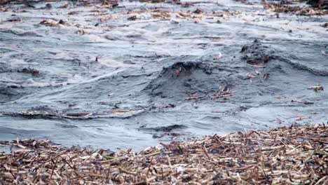 Black-muddy-water-filled-with-debris-flows-turbulently