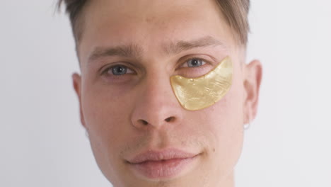 blond guy removes the golden patch under her right eye