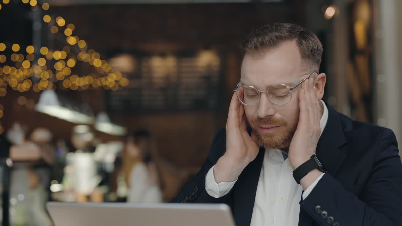 Man with Headache in Cafe