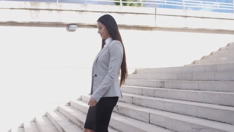 serious woman walking up staircase