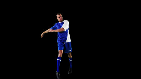 Athlete-practicing-soccer-against-black-background