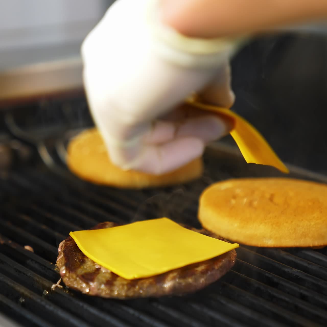 Minced ground meat cooking on grill .Beef meat patty grilling with two buns. Burger cutlet frying in diner kitchen