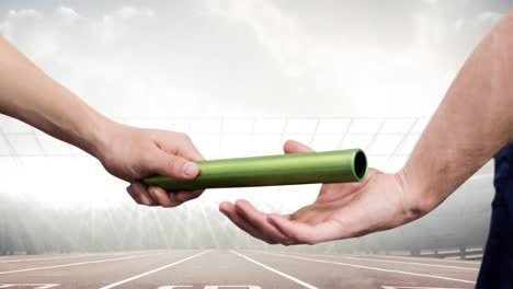 animation of athlete's hands passing relay baton over racing track in sports stadium