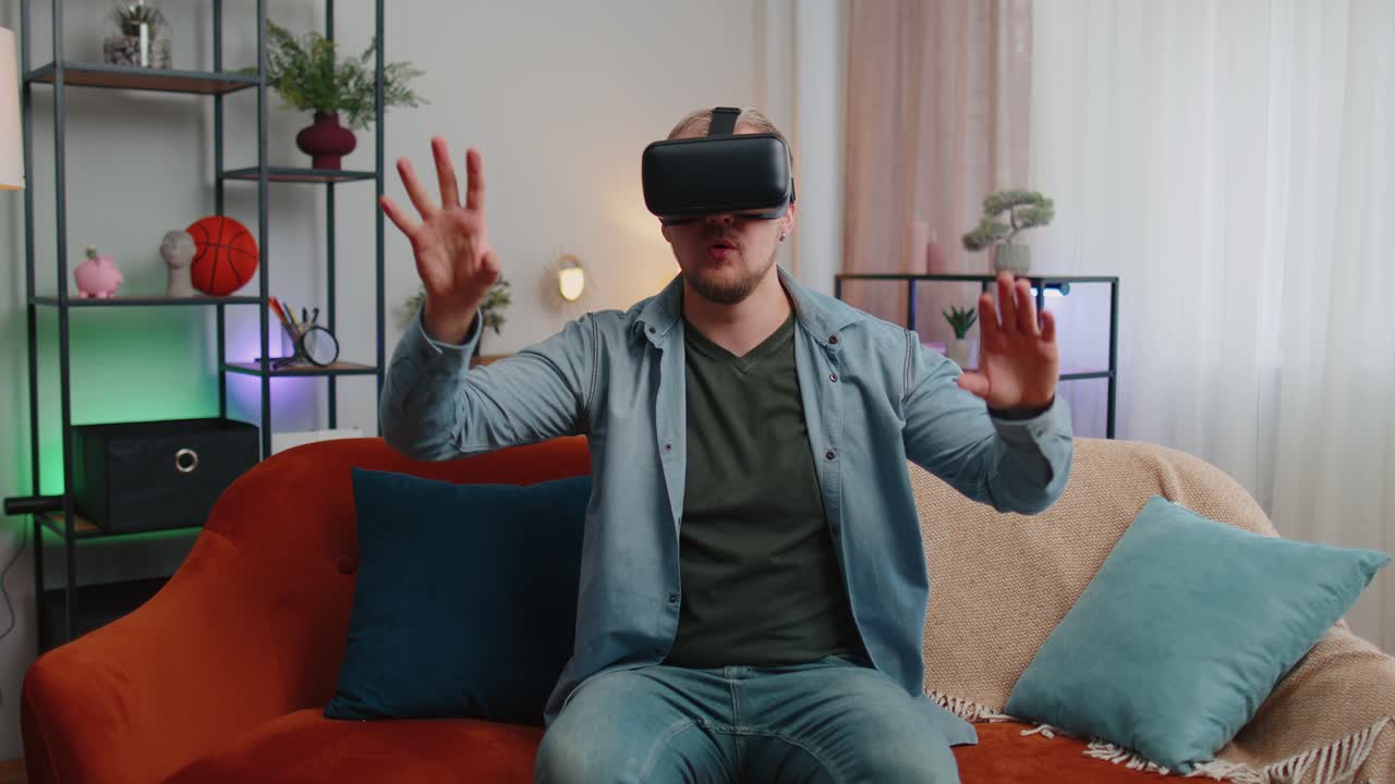 Adult man use virtual reality headset glasses at home enjoying video concept moving hands in air