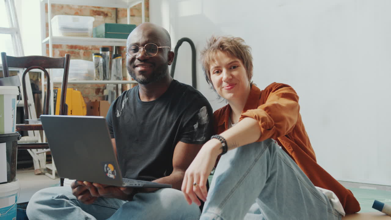 Portrait of Cheerful Family Couple with Laptop in Living Room under Renovation