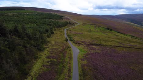 Aerial-Fly-By-over-a-Lone-Road-cutting-through-a-Barren-Irish-Mountain-Landscape