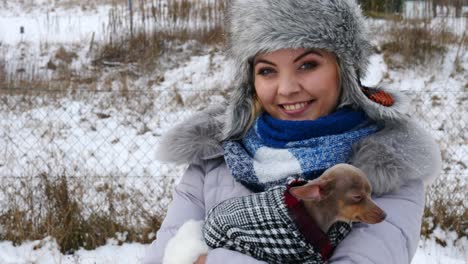 woman playing with her little dog outside winter