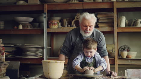 grandfather teaching grandson pottery