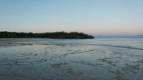 low tide in natadola bay in fiji with glassy water surface reflecting clear sky