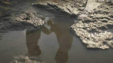 reflection on the water of couple walking