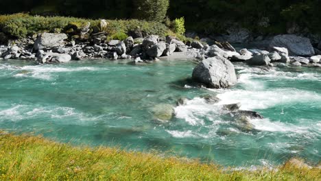 Slowly-floating-Rob-Roy-Glacier-River-during-bright-sunny-day-downhill-the-mountains