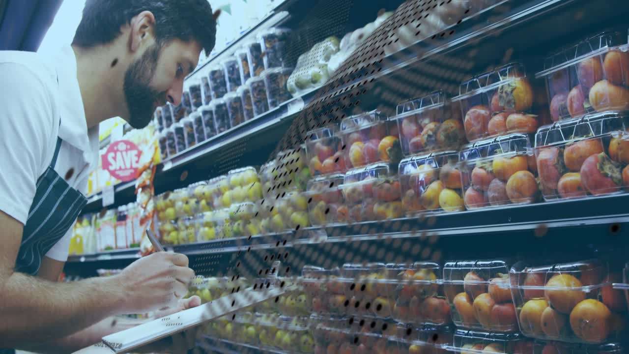 Male inspector leaning in grocery aisle, inspecting packaged fruit and noting quality on clipboard
