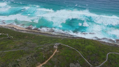 cinematic flight over cliff edge into wild waves along western australia coastline