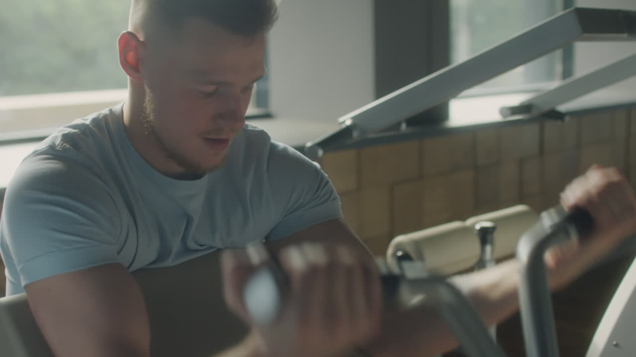 Man Exercising with Preacher Curl Machine in Gym