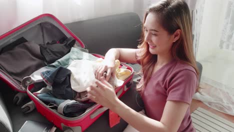 Cute-woman-folded-clothes-and-packed-a-suitcase-to-happily-prepare-for-a-trip