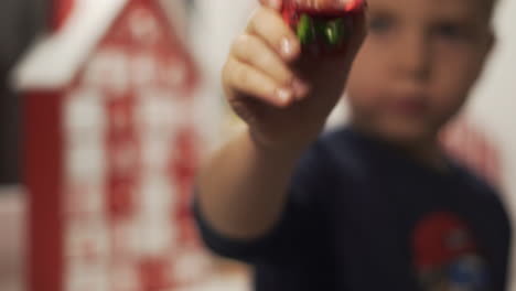 cerrar manos niño sostener bola de nieve con santa claus y calendario de adviento en el fondo borroso