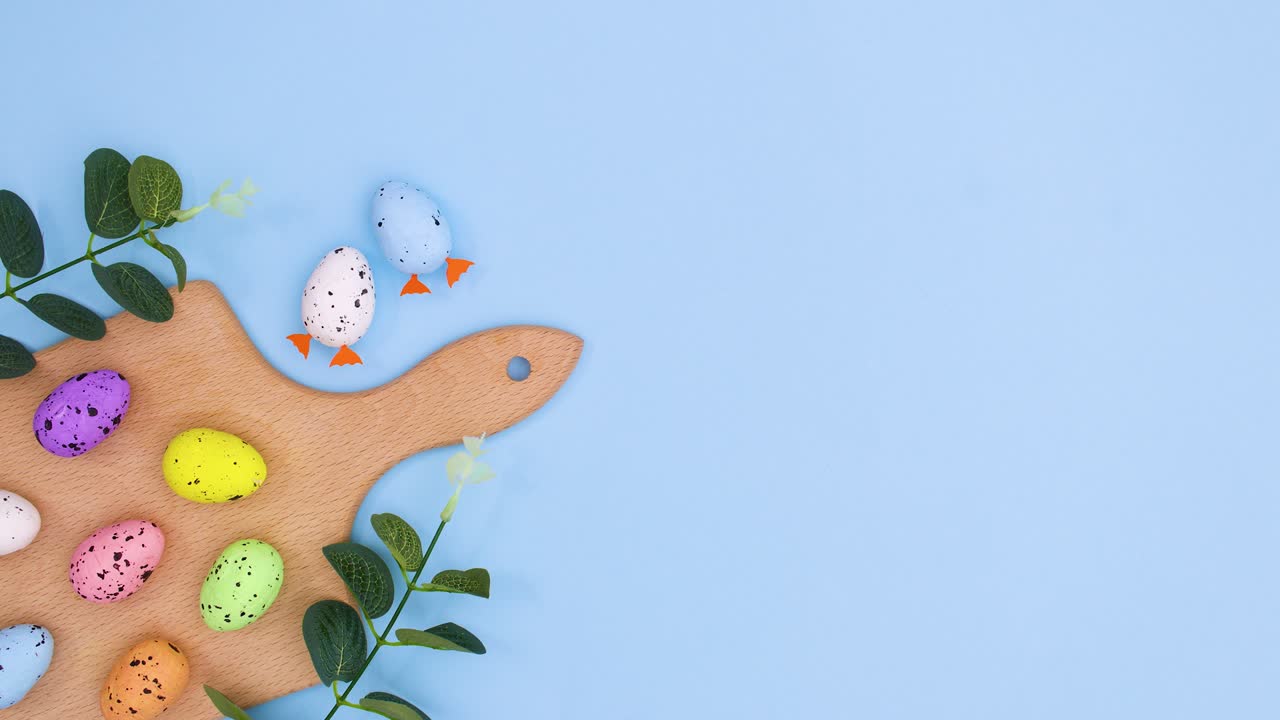 파스텔 파란색 테마의 왼쪽에 절단 보드에 행복한 부활절 장식.
