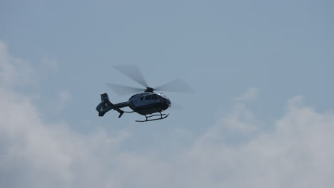 silhouette of guardia civil police helicopter flying across cloudy sky