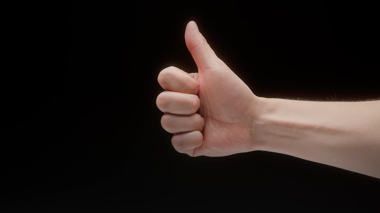 Close-up of a hand gesture on a black background, like gesture, shooting a gesturing in studio