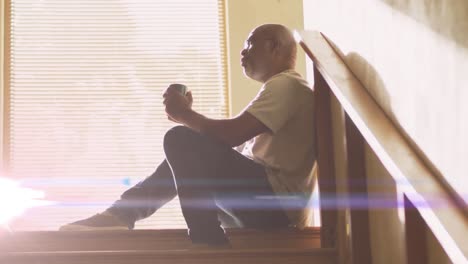 animation of glowing lights of water over a sad senior african american man