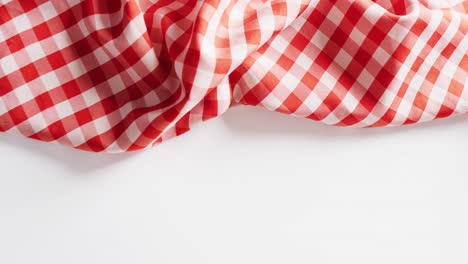 Close-up-of-red-and-white-checkered-blanket-on-white-background-with-copy-space