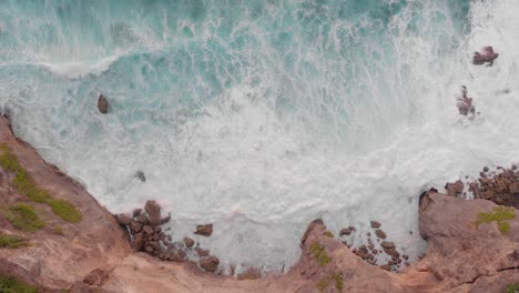 Cinematic-smooth-aerial-drone-shot-of-large-waves-crashing-into-huge-cliff-edge-in-uuwatu,-Bali-during-golden-hour-on-summer-sunset-4