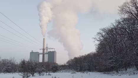 thick white steam coming from german gas power plant franken 1 in nuremberg during snowy winter day