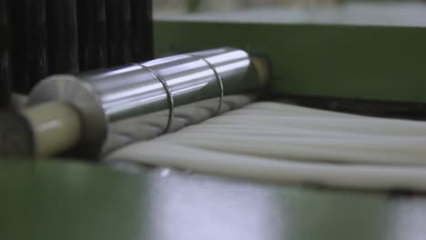 manufacturing textiles on a industrial spinning machine, cotton passing roller