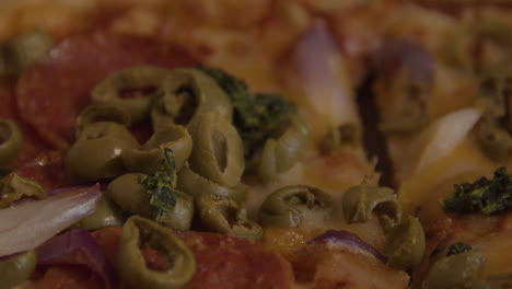 cierre la cacerola de aceitunas, cebollas y pepperoni encima de la pizza.