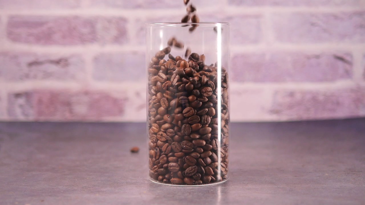 Slow Motion Coffee Beans Falling into a Glass Container