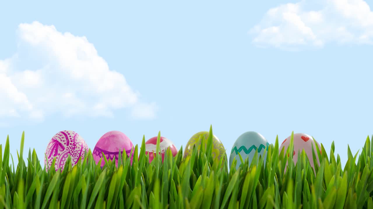 Animation of multi coloured easter eggs in grass over blue sky
