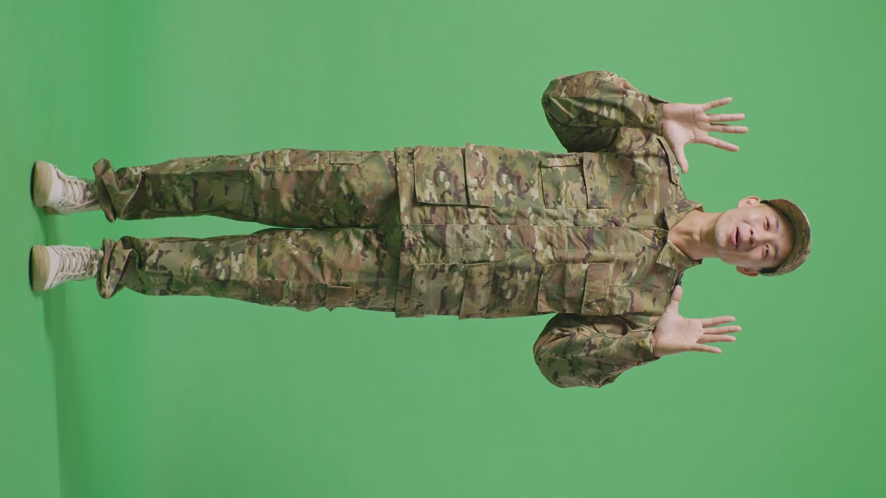 Full Body Of Asian Man Soldier Smiling And Saying Wow While Standing In The Green Screen Background Studio