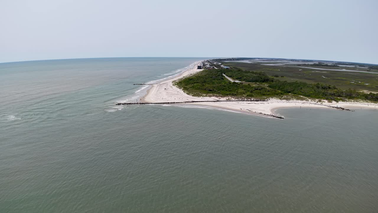 Filmato aereo realizzato con drone che riprende una stretta lingua di sabbia lungo la costa di Charleston, nella Carolina del Sud, con vegetazione verde su un lato e calme acque dell'Atlantico su entrambi i lati